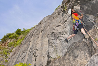 Woman climbing limestone cliff in south wales