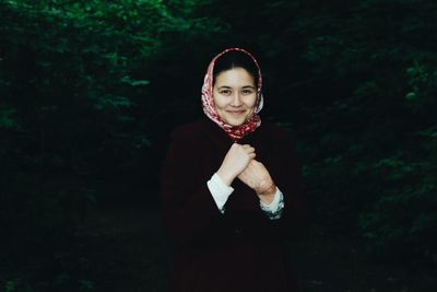 Portrait of beautiful woman wearing headscarf against plants