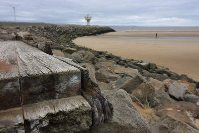 Scenic view of rocks on beach against sky