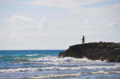 Man on sea shore against sky