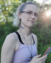 Portrait of woman wearing glasses standing outdoors