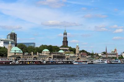 View of buildings at waterfront against cloudy sky