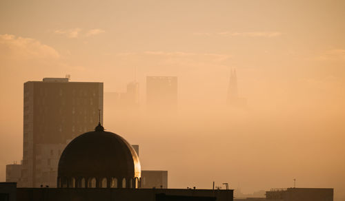 Silhouette buildings against sky during sunset in city