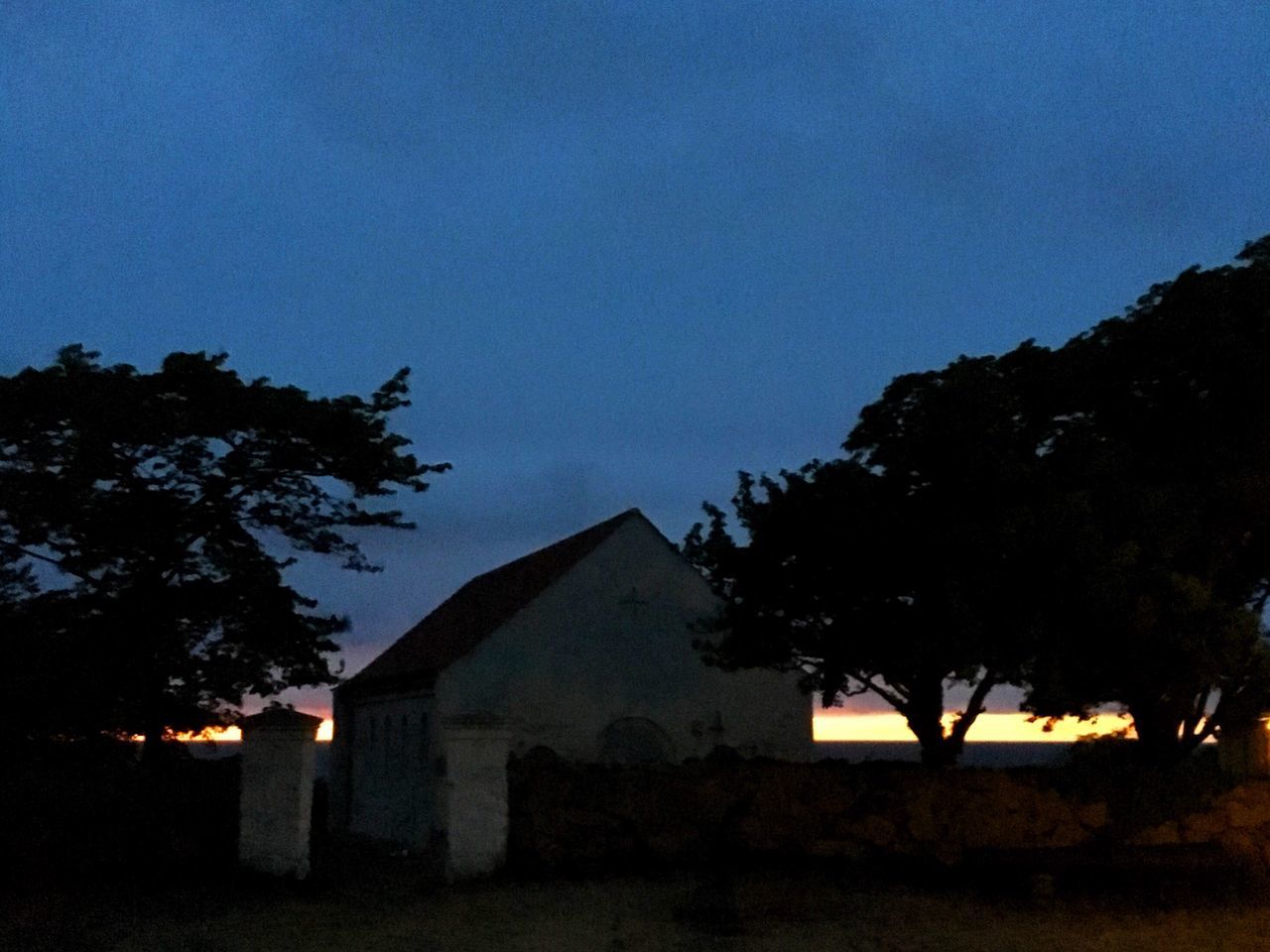 building exterior, tree, architecture, built structure, silhouette, house, clear sky, dusk, sky, copy space, blue, night, residential structure, illuminated, nature, low angle view, outdoors, residential building, no people, tranquility