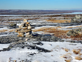 Stack of rocks in snow against sky