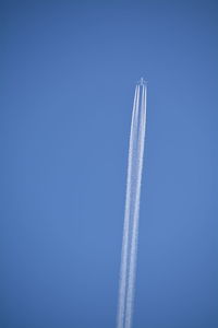 Low angle view of snow covered landscape against clear blue sky