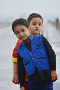 Portrait of boy standing in sea against sky