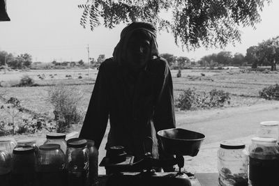 Portrait of village man standing by tree, silhouette