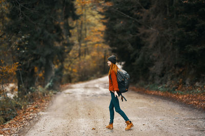 Rear view of man walking on footpath