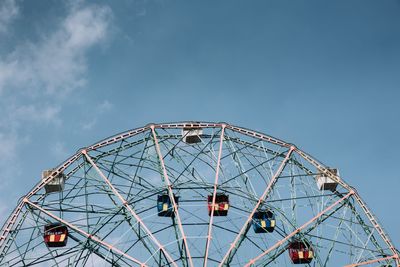 Low angle view of ferris wheel against blue sky