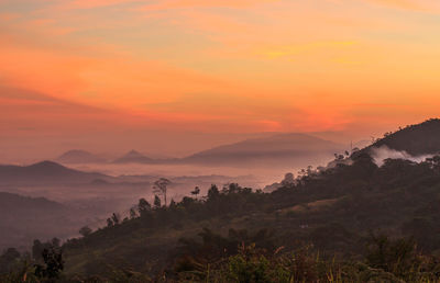 Scenic view of mountains against orange sky