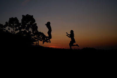 Silhouette men against sky during sunset