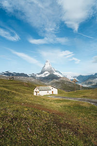 View of house on field against blue sky with matterhorn in the background
