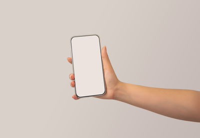 Midsection of person using smart phone against white background