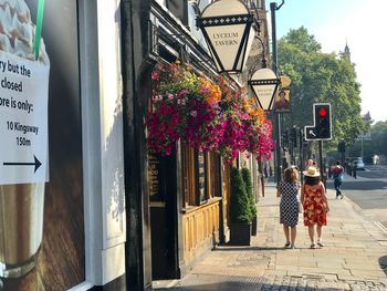 Rear view of people walking on footpath