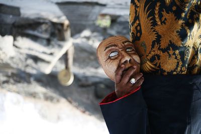 Close-up portrait of person wearing mask standing outdoors