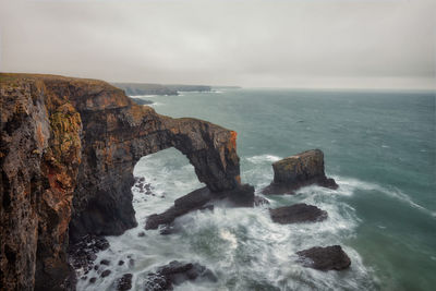 Scenic view of rocks in sea against sky