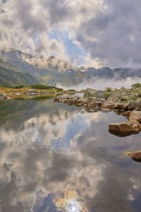 Scenic view of lake against cloudy sky