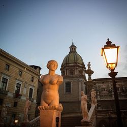 Low angle view of sculptures against palermo cathedral at dusk