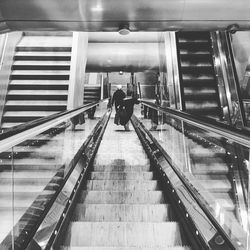 Low angle view of woman walking on escalator