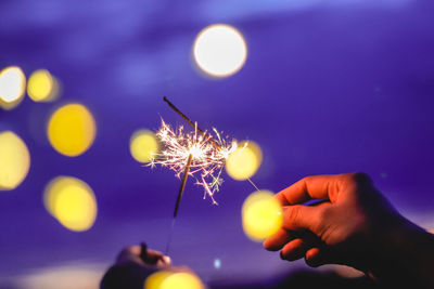 Blurred motion of person hands holding sparkler at night