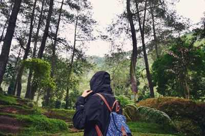 Man standing on tree trunk in forest