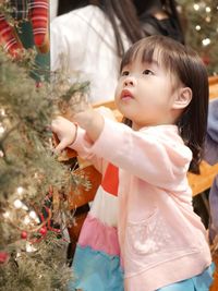 Full length of cute baby girl in christmas tree
