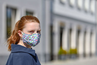 Portrait of woman wearing mask while standing outdoors