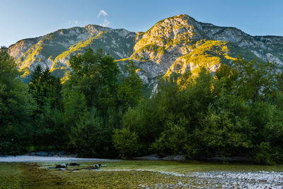 Scenic view of river by mountains against sky