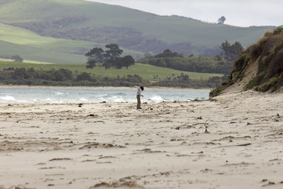 Full length of boy standing on shore at beach