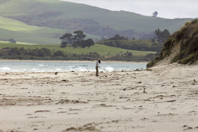 Man standing on beach against sky