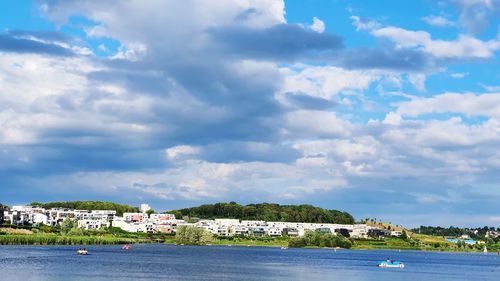 Scenic view of sea by buildings against sky