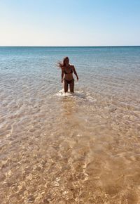 Full length of shirtless boy on beach