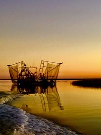 Ship in sea against sky during sunset