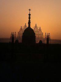 Silhouette built structures against clear sky at sunset