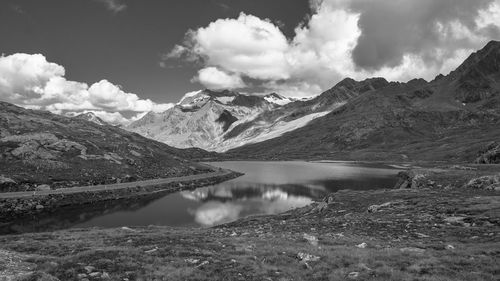 Scenic view of lake by mountains against sky