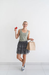 Online shopping concept. young smiling woman holding eco friendly shopping bags and creadit card. 