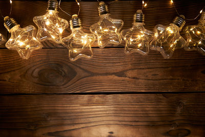 Low angle view of illuminated light bulbs hanging from ceiling