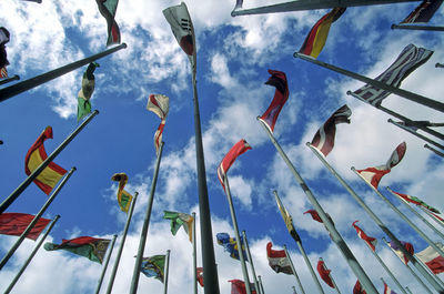 Low angle view of flags waving on pole against sky