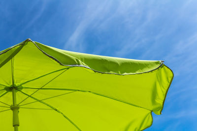 Low angle view of green parasol against blue sky