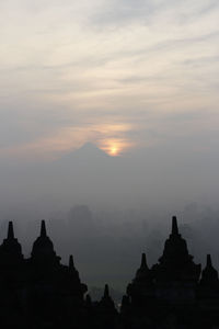 Silhouette borobudur temple with the mysteries forest surrounding during sunrise, yogyakarta
