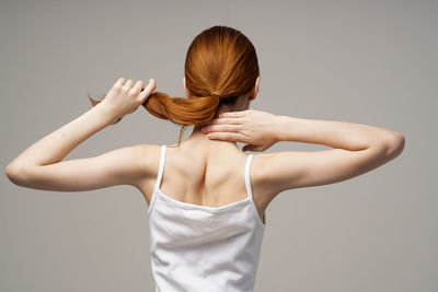 Rear view of woman standing against white background