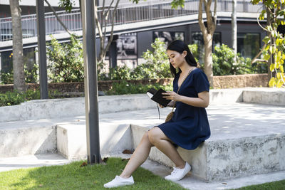 Full length of young woman using mobile phone