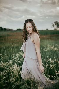 Woman standing on field against sky