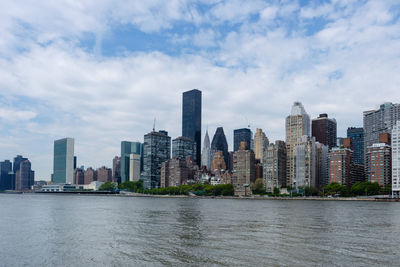 River amidst buildings in city against sky