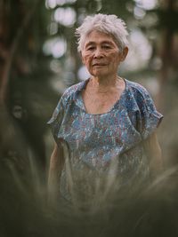 Portrait of senior woman seen through plants