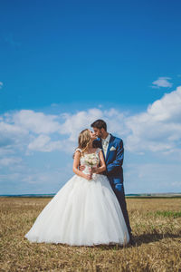 Rear view of couple on field against sky