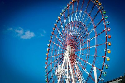 Low angle view of ferris wheel against blue sky