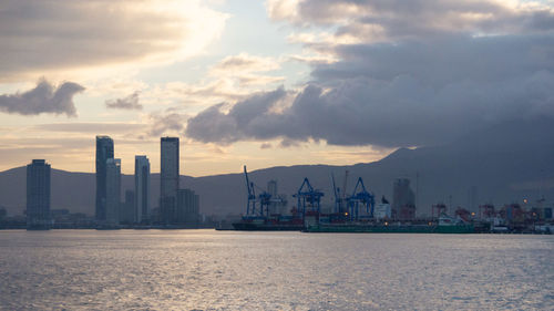 Panoramic view of sea and buildings against sky during sunset