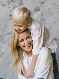 Portrait of smiling woman with son at home